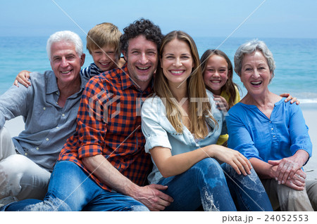 Cheerful multi-generation family relaxing at beach Cheerful multi-generation family relaxing at beach 24052553