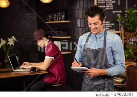 Waiter writing down the orders Waiter writing down the orders 24052607