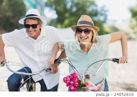 Portrait smiling couple ridding bike Portrait smiling couple ridding bike 24052610