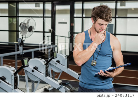 Gym trainer looking at the clipboard 24053117