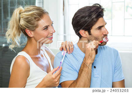 Couple brushing their teeth in bathroom Couple brushing their teeth in bathroom 24053203