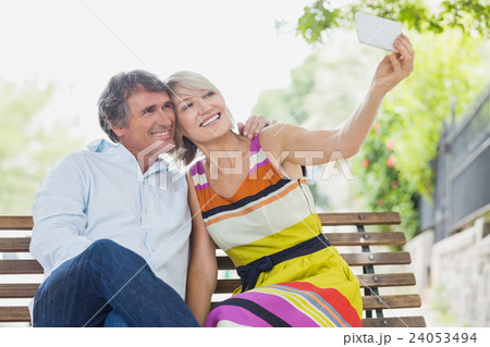 Couple taking selfie in park Couple taking selfie in park 24053494