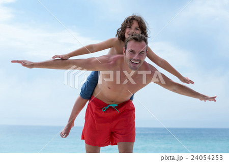 Happy father carrying son at beach Happy father carrying son at beach 24054253