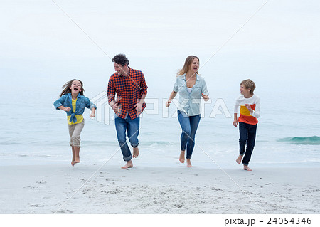 Cheerful family running at sea shore against sky Cheerful family running at sea shore against sky 24054346