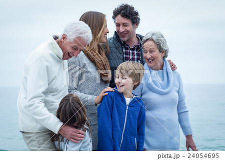 Family standing at beach Family standing at beach 24054695