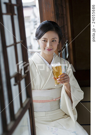 着物姿でビールを飲む女性の写真素材