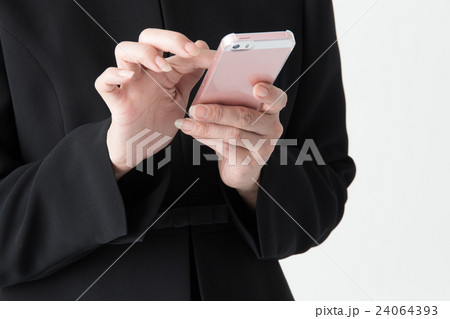 礼服のミドル女性(スマホ手元)・白バック 礼服のミドル女性(スマホ手元)・白バック 24064393