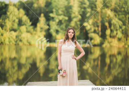 Gorgeous bride in elegant dress holding bouquet Gorgeous bride in elegant dress holding bouquet 24064411