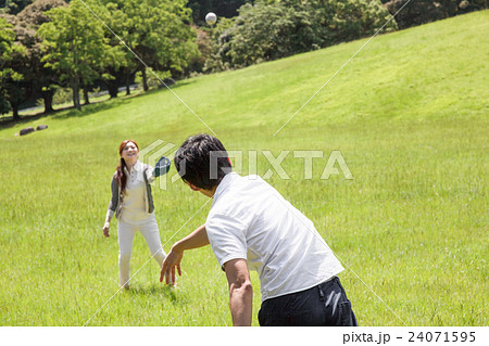 公園でキャッチボールをする男女の写真素材