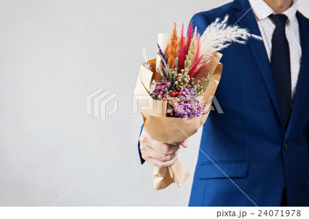 Young man in fashionable suit holding bouquet 24071978