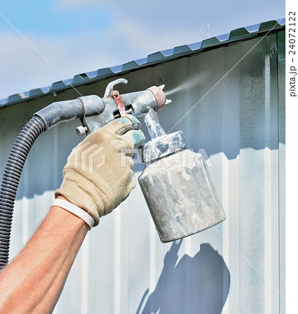 Spraying white paint onto a galvanized surface. 24072122