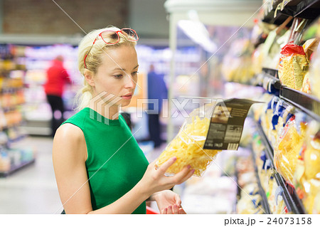 Woman shopping groceries at supermarket. 24073158