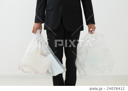 ゴミ袋を持つスーツを着た男性 24076412