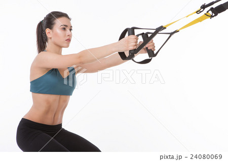 Woman training with suspension trainer sling 24080069