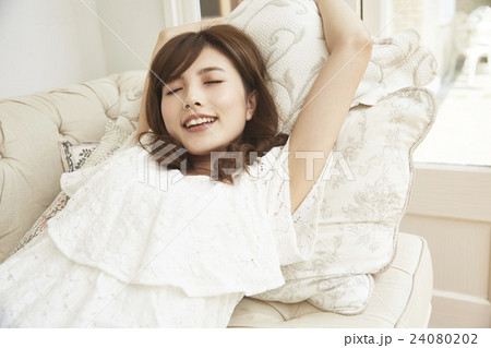 ソファに寝転び伸びをする女性 ソファに寝転び伸びをする女性 24080202