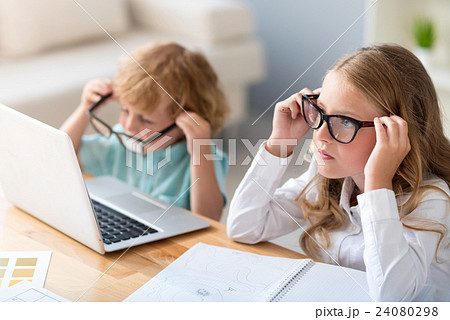 Boy and girl putting on glasses Boy and girl putting on glasses 24080298