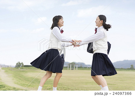 両手をつなぐ2人の女子学生の写真素材