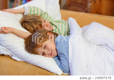 Two little blond sibling boys sleeping in bed Two little blond sibling boys sleeping in bed 24097579