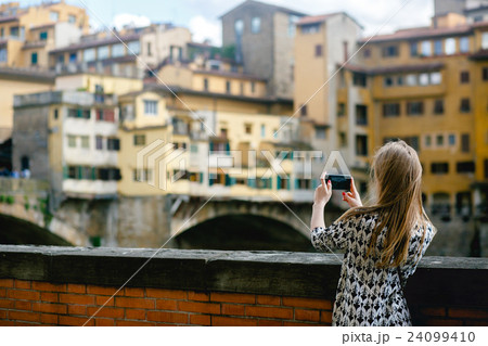 Girl takes a picture of an old city on her phone Girl takes a picture of an old city on her phone 24099410