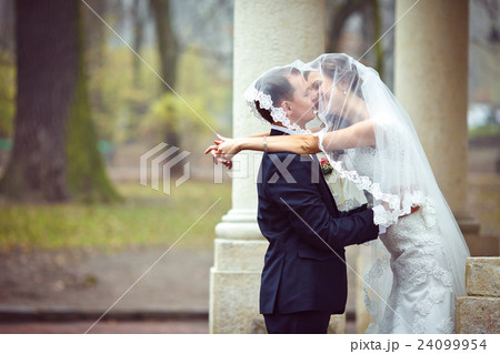 Groom kisses a bride standing hidden  24099954