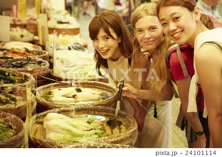 市場を観光する外国人女性と日本人女性 24101114