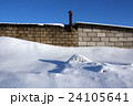 Old brick building and snow pile. 24105641