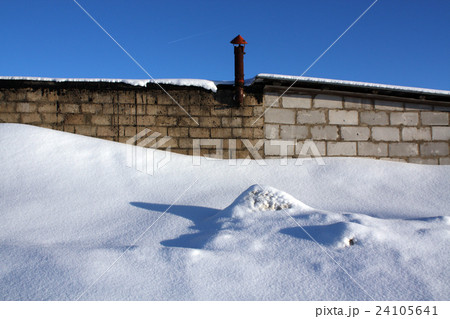 Old brick building and snow pile. 24105641