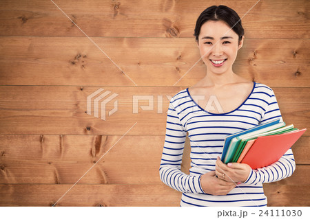 Composite image of happy woman holding files Composite image of happy woman holding files 24111030