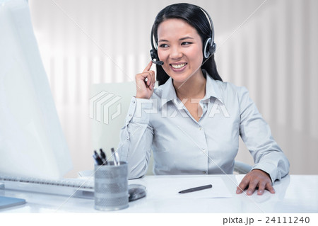 Composite image of smiling businesswoman using headset 24111240