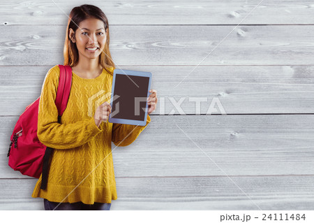 Composite image of smiling asian female student showing tablet 24111484