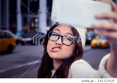 Composite image of asian woman making faces and taking selfie Composite image of asian woman making faces and taking selfie 24112419