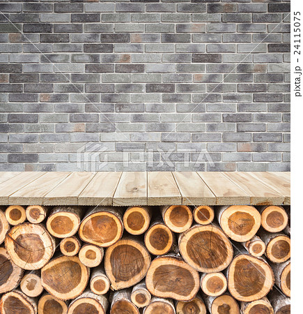 Empty top of wooden table or counter with pile wood log and stone wall. Interior decoration for product display Empty top of wooden table or counter with pile wood log and stone wall. Interior decoration for product display 24115075