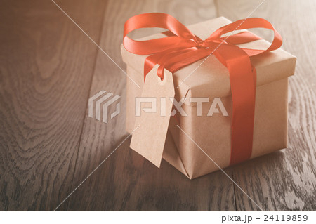 rustic present box with red ribbon on wood table rustic present box with red ribbon on wood table 24119859