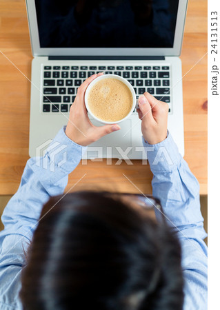 Top view of woman drink of coffee and use of laptop computer 24131513