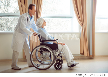 Senior woman in wheelchair with her doctor Senior woman in wheelchair with her doctor 24139751