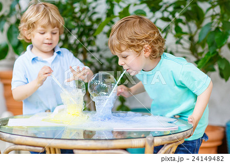 two twin boys making experiment with colorful 24149482