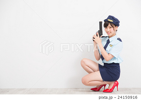 おもちゃのピストルを持った婦人警官のコスプレをした女性 24150916