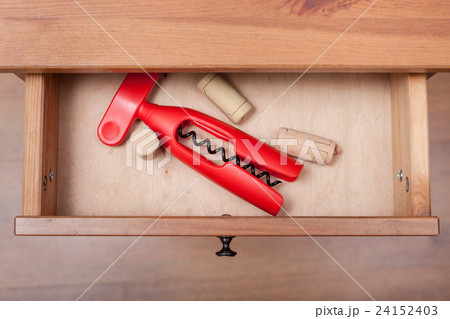 red corkscrew and cork from wine bottles in drawer 24152403