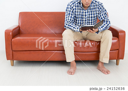 ソファに座る若い男性の写真素材