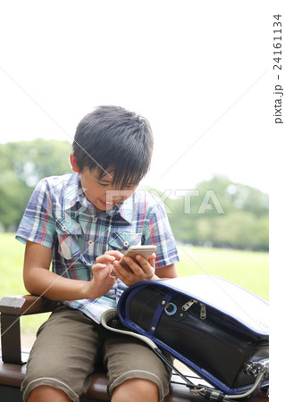 スマホを使用する小学生 24161134