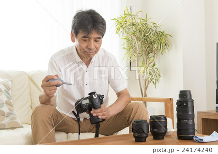 カメラの手入れをする男性 24174240