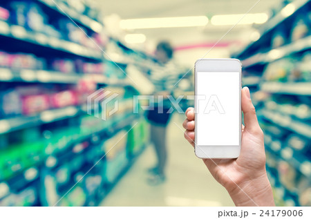 Female hand holding mobile smart phone touch screen on Abstract blurred photo of store with trolley in department store bokeh background 24179006