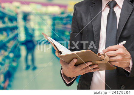 Businessman writing the note book on Abstract blurred photo of store in department store bokeh background Businessman writing the note book on Abstract blurred photo of store in department store bokeh background 24179204