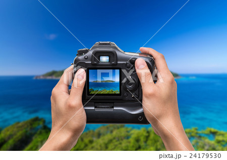 Hands holding the camera which taking photo of Similan islands, Beautiful view of the rock Sail, Thailand Hands holding the camera which taking photo of Similan islands, Beautiful view of the rock Sail, Thailand 24179530