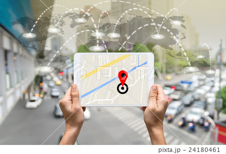 female hands holding a tablet showing part of navigator map on connection line over the world map with blurred photo of traffic jam, Navigation concept,Elements of this image furnished by NASA 24180461
