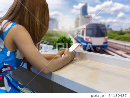 woman using the mobile phone on the seat with Abstract blurred photo of sky train at the rush hour background, Shopping Online With Digital laptop, technology and internet concept woman using the mobile phone on the seat with Abstract blurred photo of sky train at the rush hour background, Shopping Online With Digital laptop, technology and internet concept 24180487