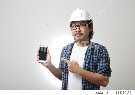 The Asian engineer points at mobile phone. 24181429