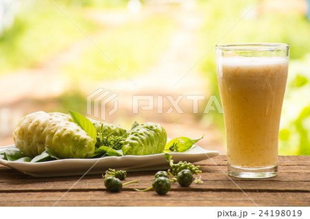 Noni and noni juice on wooden background.Juice  24198019