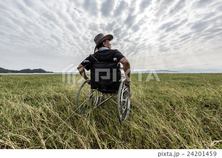 Man on a wheelchair relaxing in a park 24201459