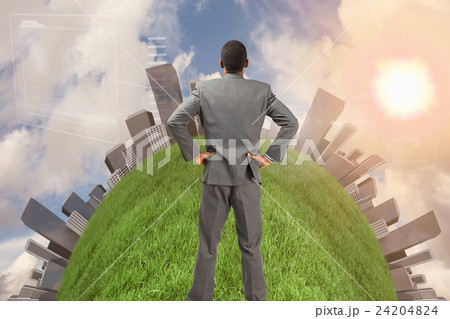 Composite image of businessman standing with hands on hips 24204824